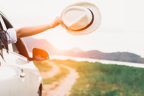 Hand holding hat out of window